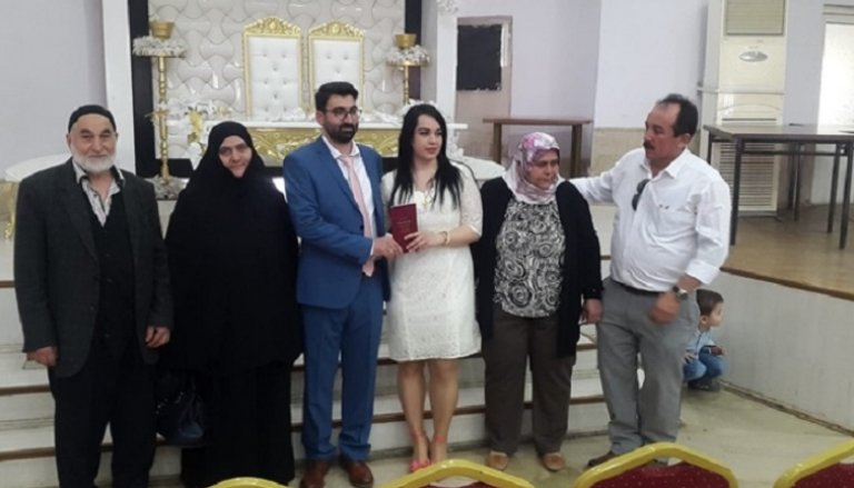 العروسان والعائلة أثناء عقد القران.