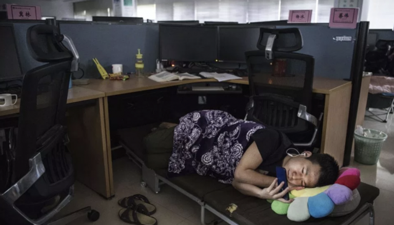 موظف يأخذ قسطا من الراحة تحت مكتبه