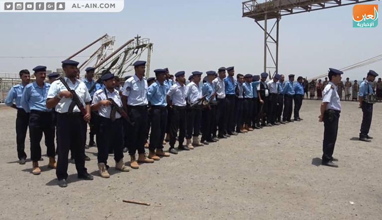 عناصر حوثية بزي مدني قبل تسليم الميناء لآخرين بملابس خفر السواحل