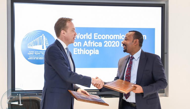 رئيس الوزراء الإثيوبي ورئيس منتدى دافوس أثناء توقيع الاتفاق 