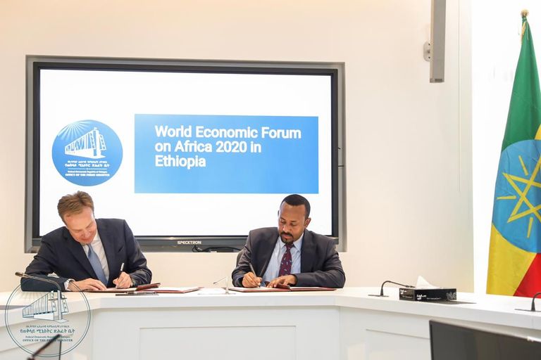 رئيس الوزراء الإثيوبي ورئيس منتدى دافوس أثناء توقيع الاتفاق