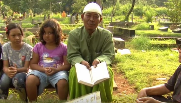 إندونيسيون فقراء يتلون القرآن بالمقابر في رمضان لزيادة دخلهم