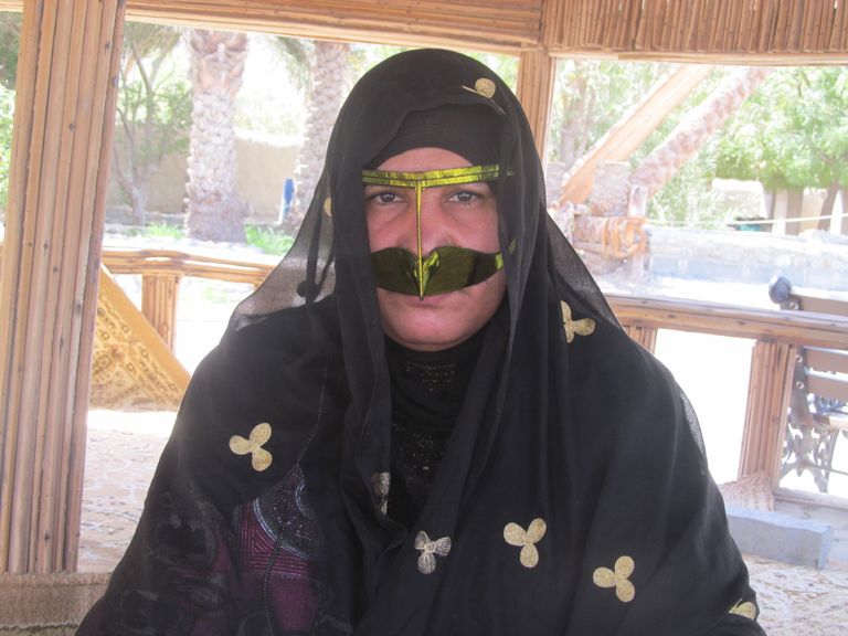 "أم سيف" مُطلعةً على أحد المراجع.