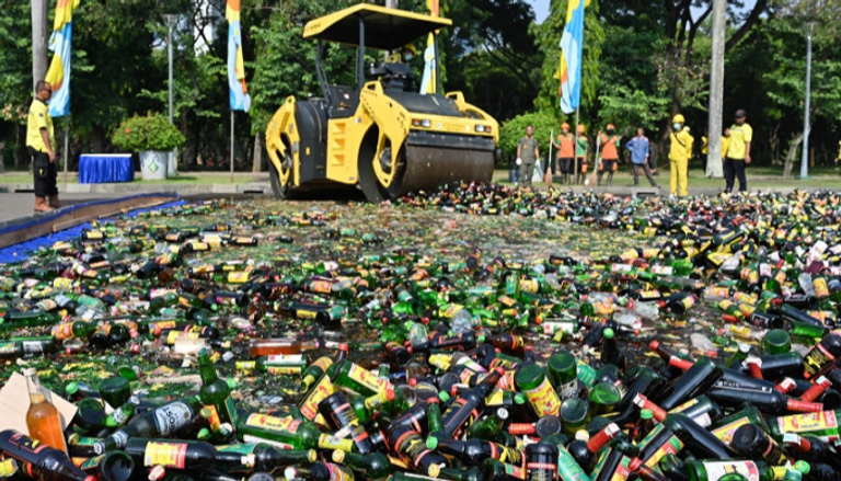 عربة ذات عجلات سميكة تسحق الآلاف من زجاجات الكحول