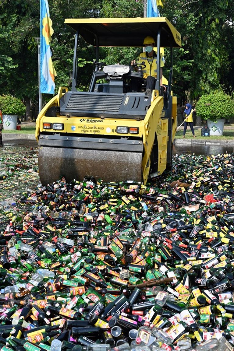 عربة ذات عجلات سميكة تسحق الآلاف من زجاجات الكحول