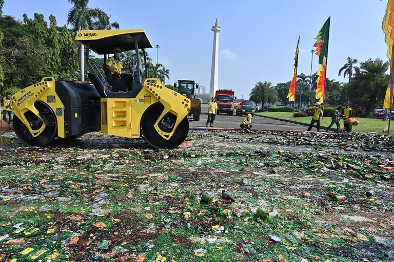 عربة ذات عجلات سميكة تسحق الآلاف من زجاجات الكحول