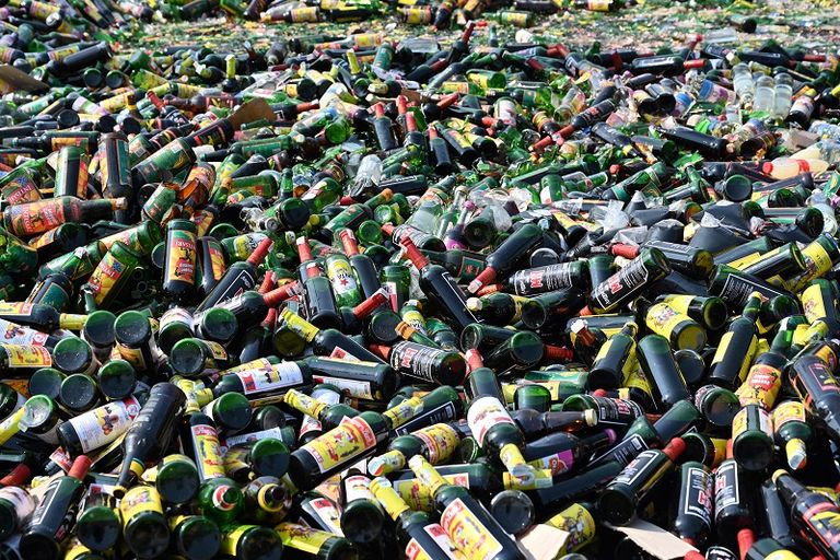 عربة ذات عجلات سميكة تسحق الآلاف من زجاجات الكحول