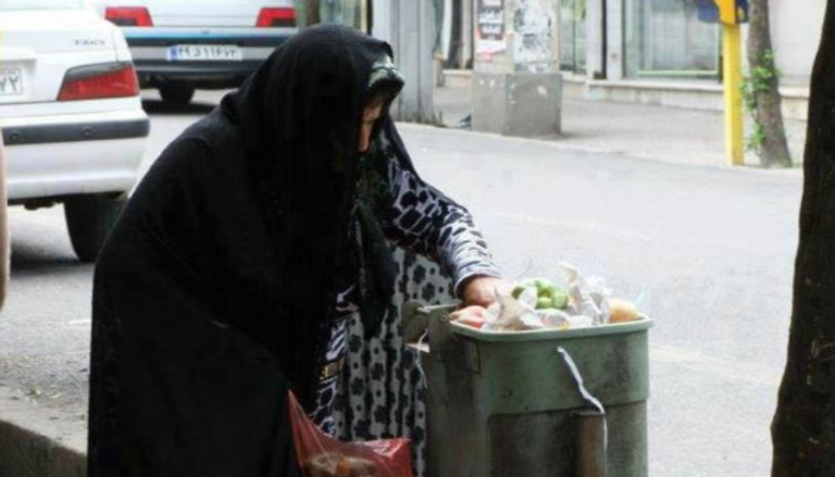 إيرانية تفتش في أحد صناديق القمامة بحثا عن طعام - أرشيفية