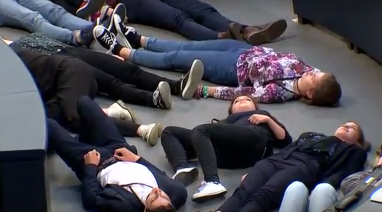 الشباب افترشوا الأرض أمام المنصة في محاكاة لمجموعة جثث على الأرض