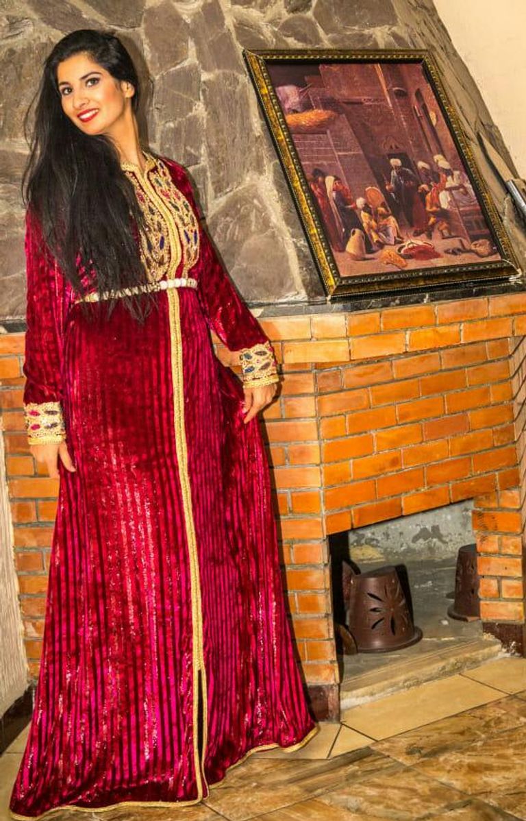 كاميليا قجاج بجانب إحدى لوحاتها