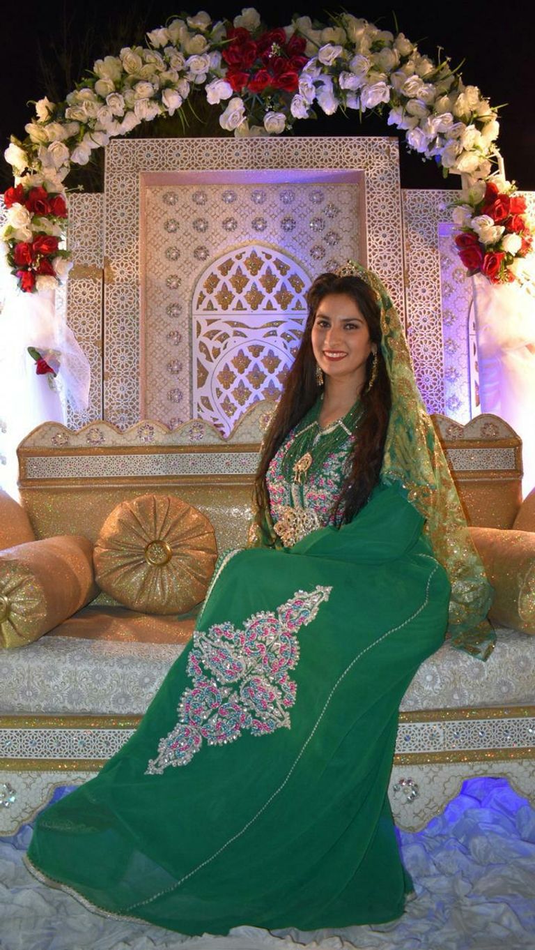 كاميليا قجاج بجانب إحدى لوحاتها