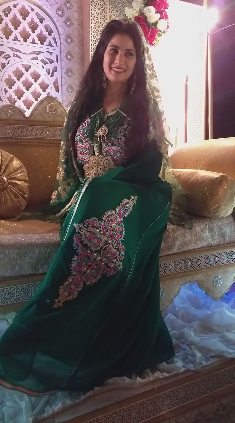 كاميليا قجاج بجانب إحدى لوحاتها