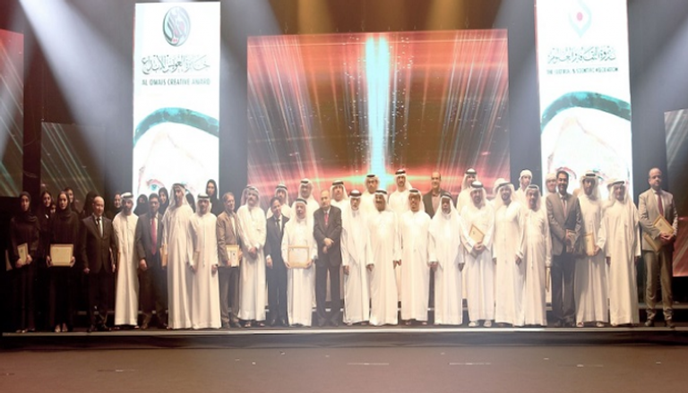 الرسامة الإماراتية منى الخاجة بجانب لوحتها "مسجد البدية"