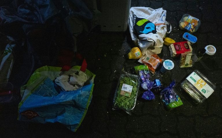 شاب يفتش في سلة قمامة تابعة لمتجر كبير في برلين