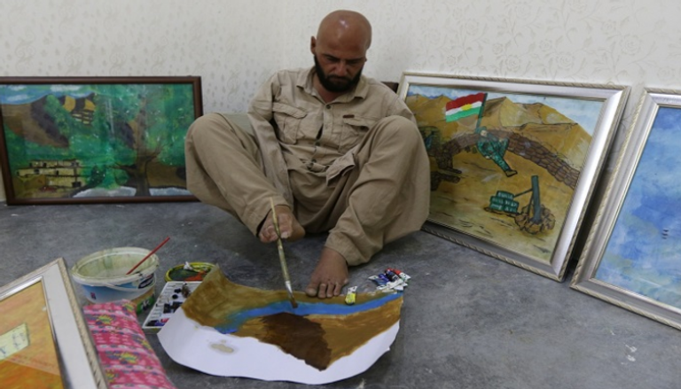 الفنان العراقي أراس عثمان يرسم بقدميه بعد أن فقد ذراعيه في حادث