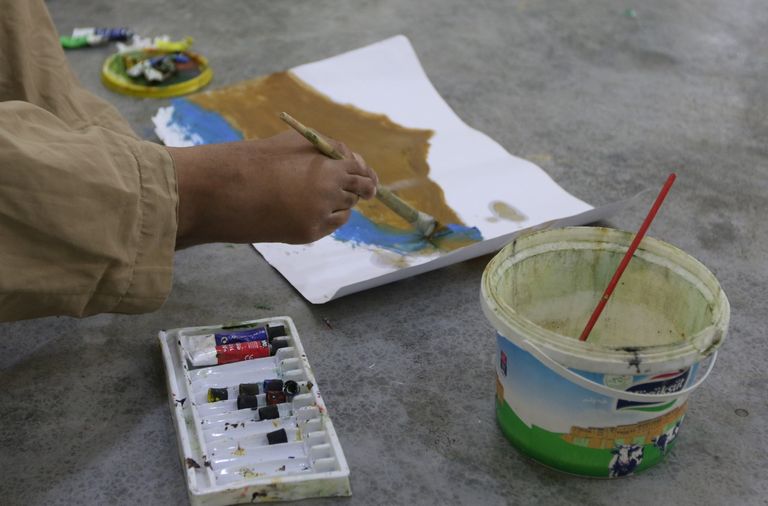 الفنان العراقي أراس عثمان يرسم بقدميه بعد أن فقد ذراعيه في حادث