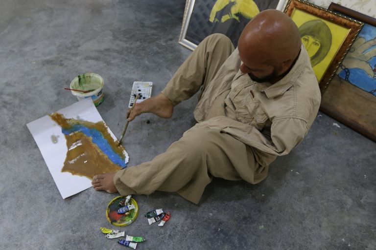 الفنان العراقي أراس عثمان يرسم بقدميه بعد أن فقد ذراعيه في حادث