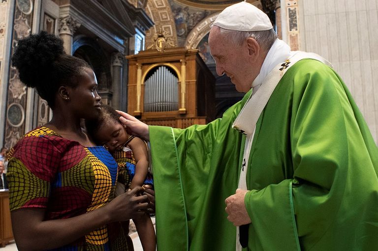البابا فرنسيس يتحدث إلى إحدى المهاجرات خلال القداس