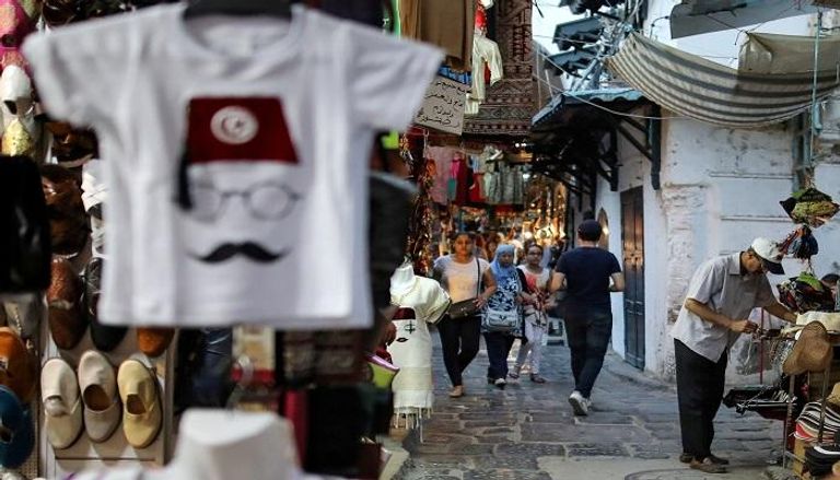 سياح يتفقدون الهدايا التذكارية المعروضة للبيع في تونس - رويترز