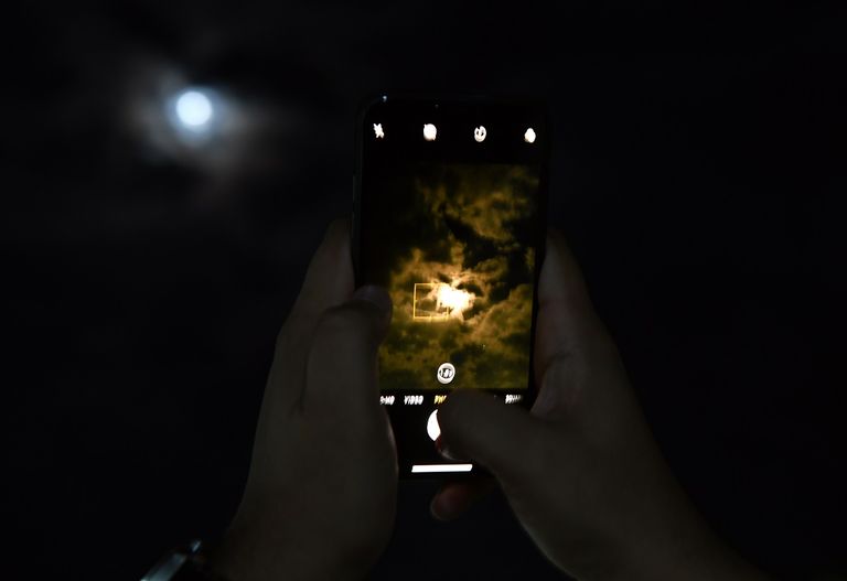 متفرّج يرفع العلم الهندي وسط حشود تحضر إطلاق مهمة "شاندرايان-2"