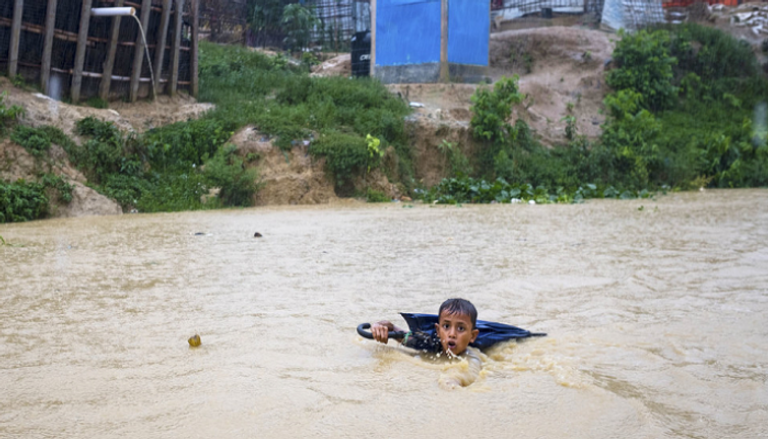 طفل صغير في بنجلاديش يتنقل في نهر شكلته الأمطار الموسمية