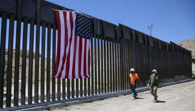 عمال بناء أمريكيون يسيرون عبر حاجز جديد على الحدود مع المكسيك