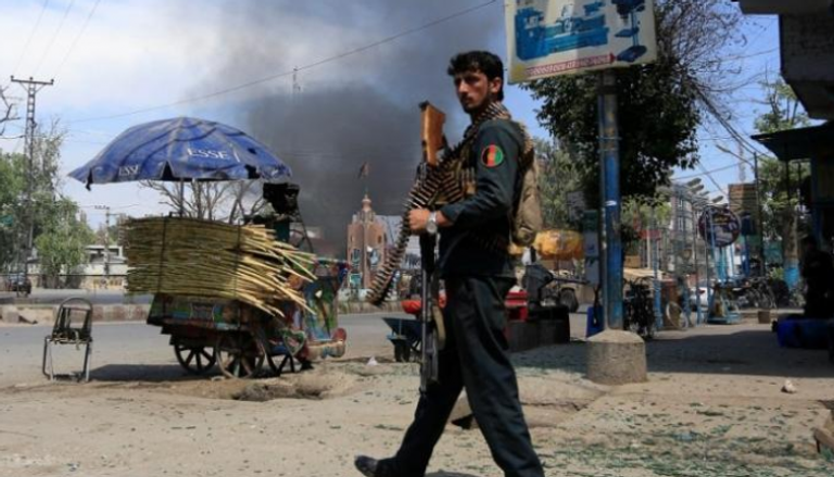 رجل أمن أفغاني يقف بالقرب من انفجار في أفغانستان