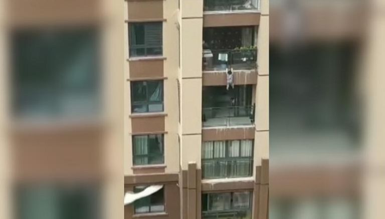 الطفل الصيني معلق في شرفة أحد المنازل