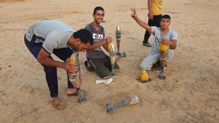 فلسطينيون مع قنابل الإنارة التي أطلقتها إسرائيل ليلا سماء قطاع غزة بعد إطلاق قنابل الإنارة
