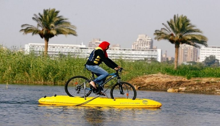 مصريون يستمتعون بالتجول فوق سطح النيل بالدراجات