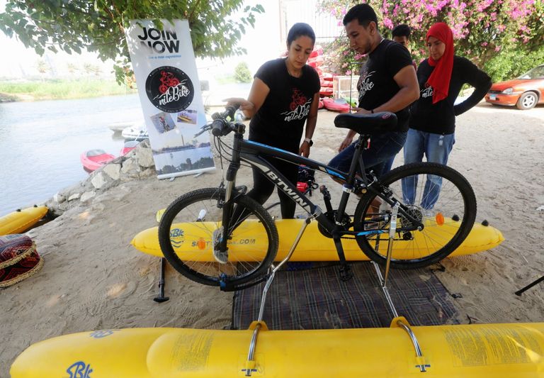 مصريون يستمتعون بالتجول فوق سطح النيل بالدراجات