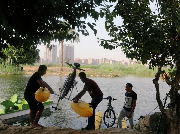 مصريون يستمتعون بالتجول فوق سطح النيل بالدراجات