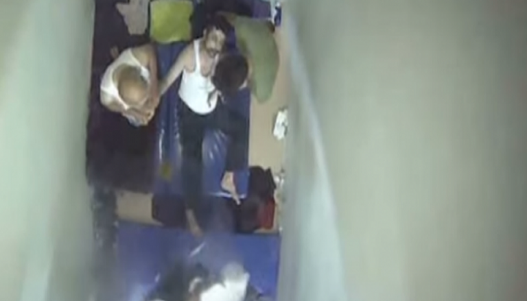 زملاء المعلم التركي يحاولون إسعافه بالزانزانة