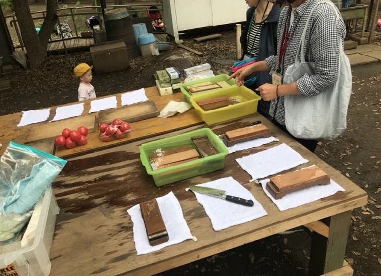 طفل بالحديقة يستخدم مطرقة على لوح خشب