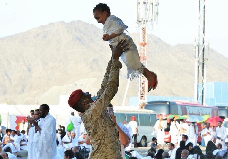 جندي يحمل شيخاً لمساعدته على أداء المناسك