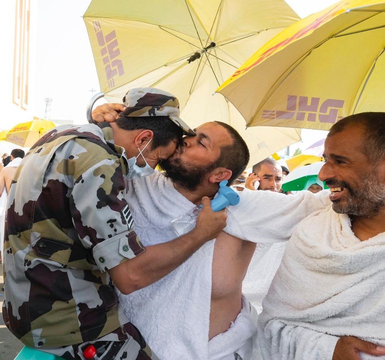 جندي يحمل شيخاً لمساعدته على أداء المناسك