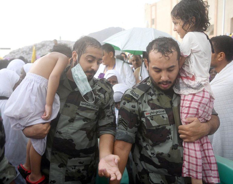 جندي يحمل شيخاً لمساعدته على أداء المناسك