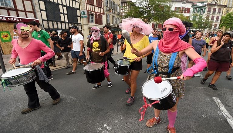 متظاهر يبعد قنبلة غاز عن محيط المظاهرات - الفرنسية