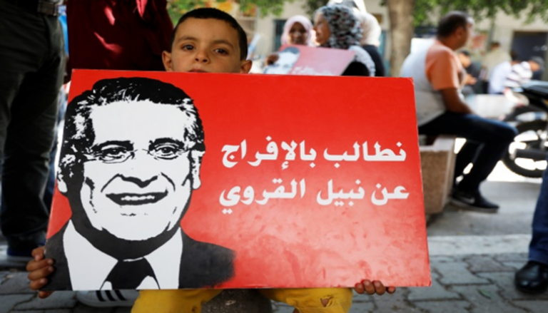طفل يحمل لافتة في مظاهرة تطالب بالإفراج عن نبيل القروي بتونس