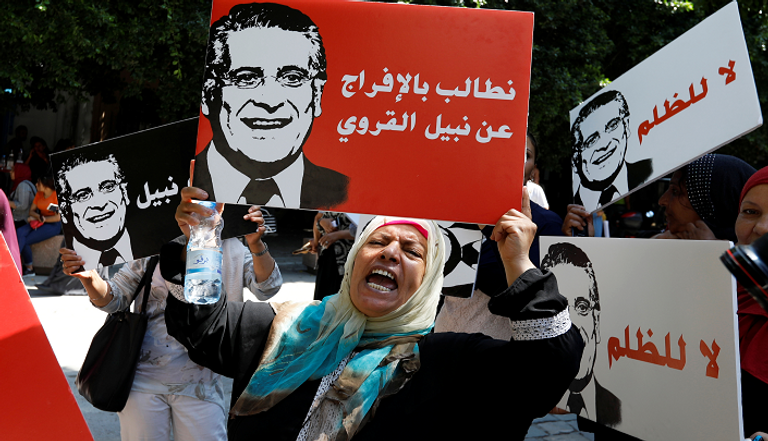 طفل يحمل لافتة في مظاهرة تطالب بالإفراج عن نبيل القروي بتونس