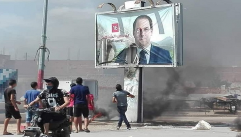 تونسيون يحرقون لافتة للشاهد في أحد شوارع البلاد