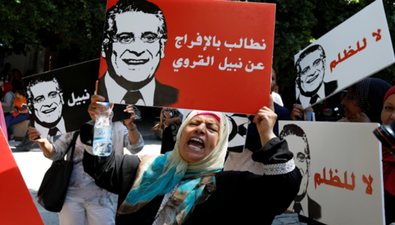 امرأة تحمل لافتة بمظاهرة تطالب بالإفراج عن نبيل القروي