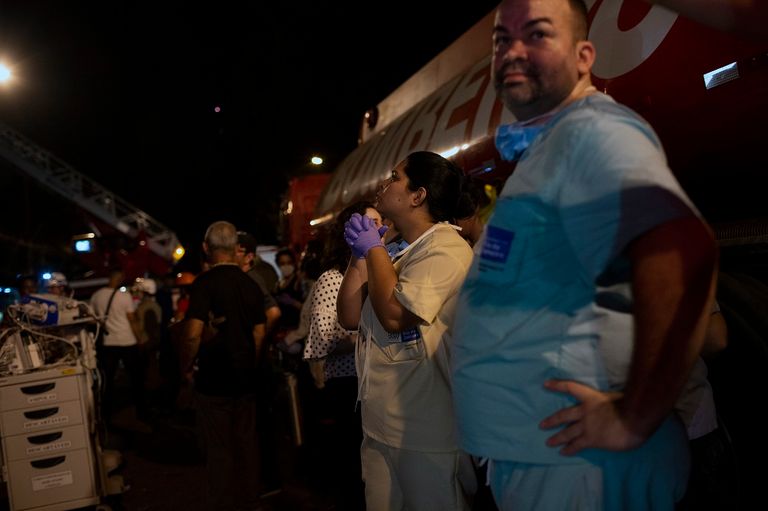 فرق الإطفاء تحمل أحد ضحايا الحريق