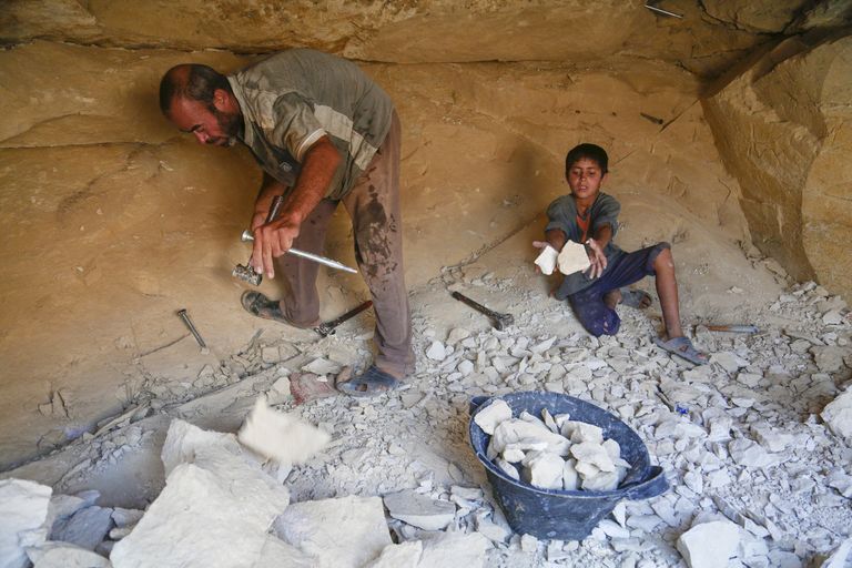 أم جمعة وأولادها أمام الحافلة التي اتخذوها منزلا لهم