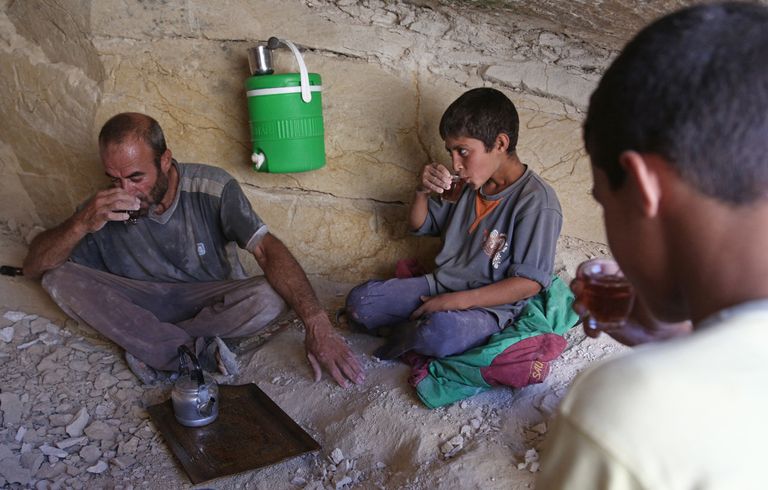 أم جمعة وأولادها أمام الحافلة التي اتخذوها منزلا لهم