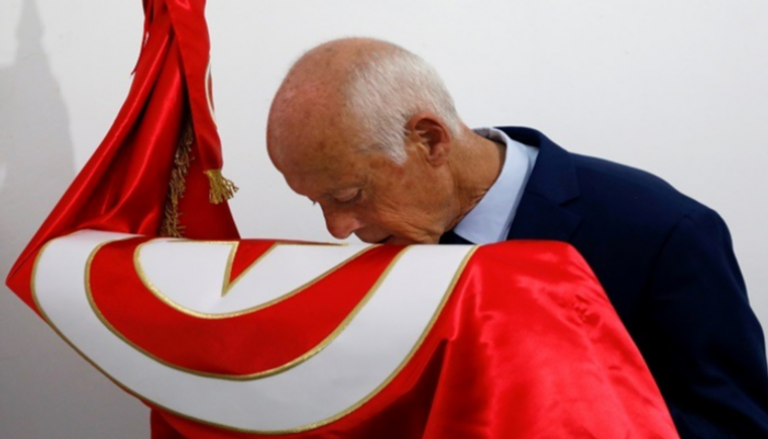 المرشح الرئاسي التونسي قيس سعيد يقبل علم بلاده