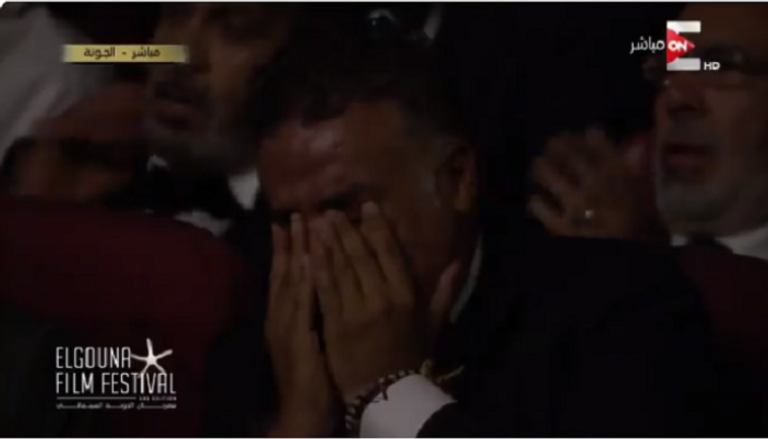 أحمد الفيشاوي يقف باكيا لوداع صورة والده فاروق الفيشاوي في مهرجان الجونة
