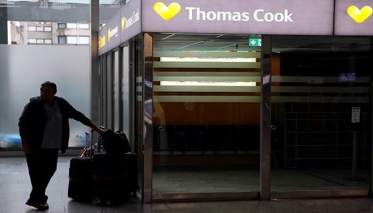 سائح يقف بجوار مكتب توماس كوك في مطار فرانكفورت