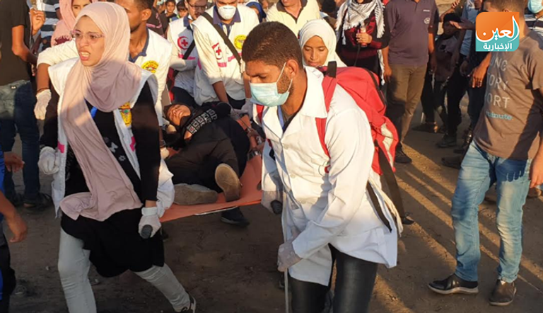 نقل أحد المصابين في مسيرة جمعة انتفاضة الأقصى