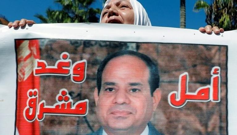 سيدة مسنة مصرية ترفع لافتة مؤيدة للرئيس عبدالفتاح السيسي